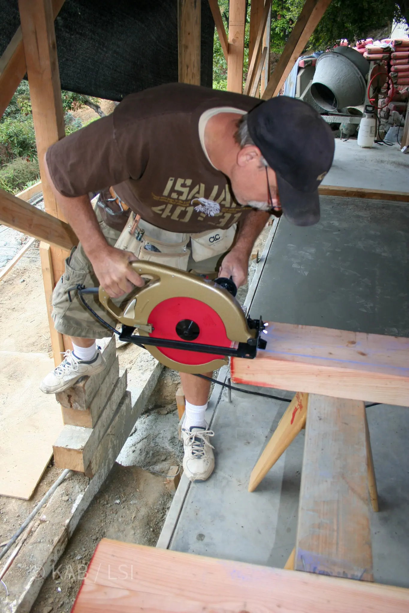 Foreman Kyle in an Isaiah 40:31 shirt using a new Makita beam saw to chamfer a slight slope into each of twenty 4x8 deck beams for a La Habra Heights observation view deck