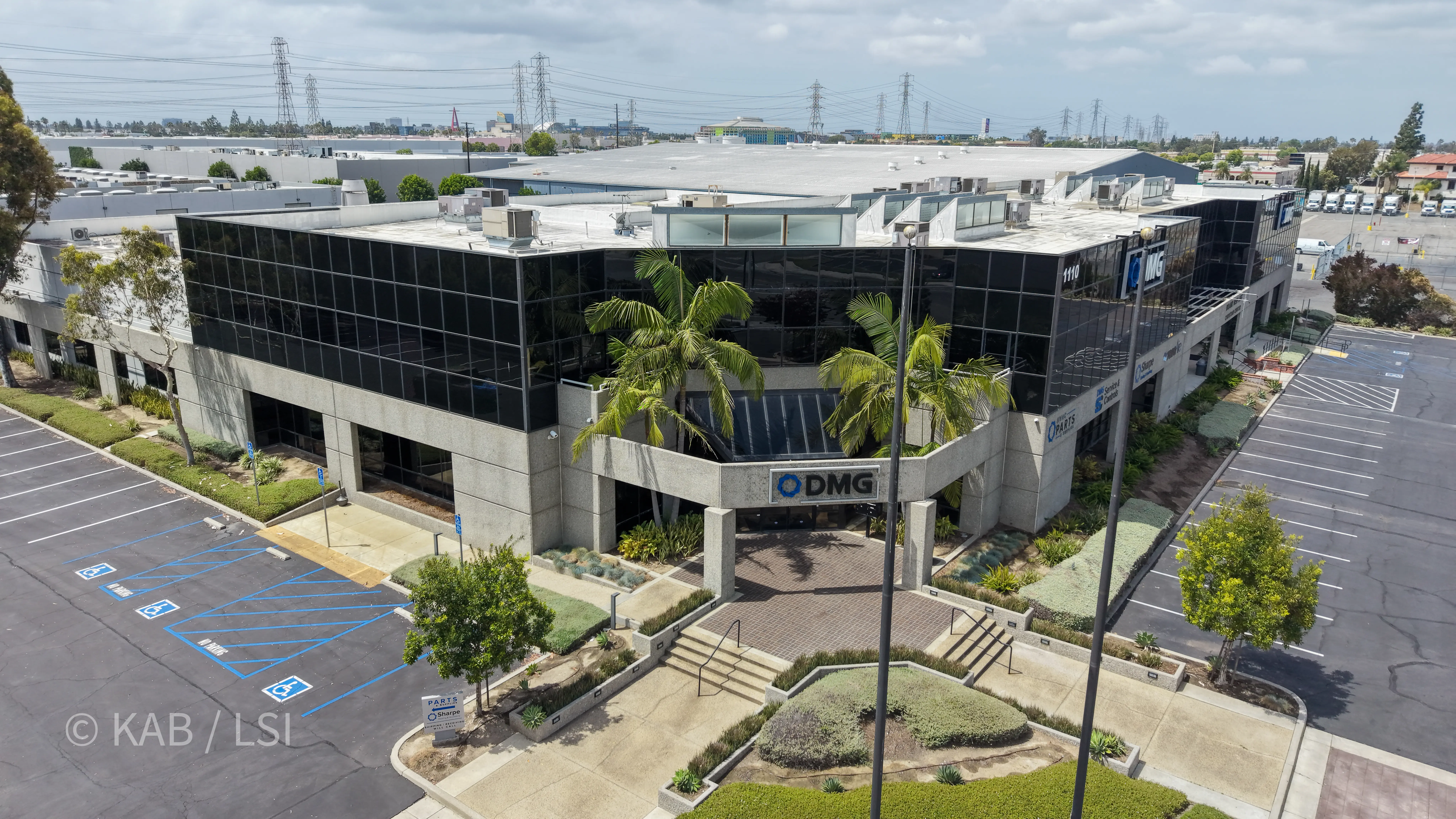 Aerial view of the front entry of the 88,000 sq ft commercial building at 1110 W. Taft Ave., Orange, CA, with DMG HVAC signage above the entrance and the full manufacturing footprint visible behind the office wing.