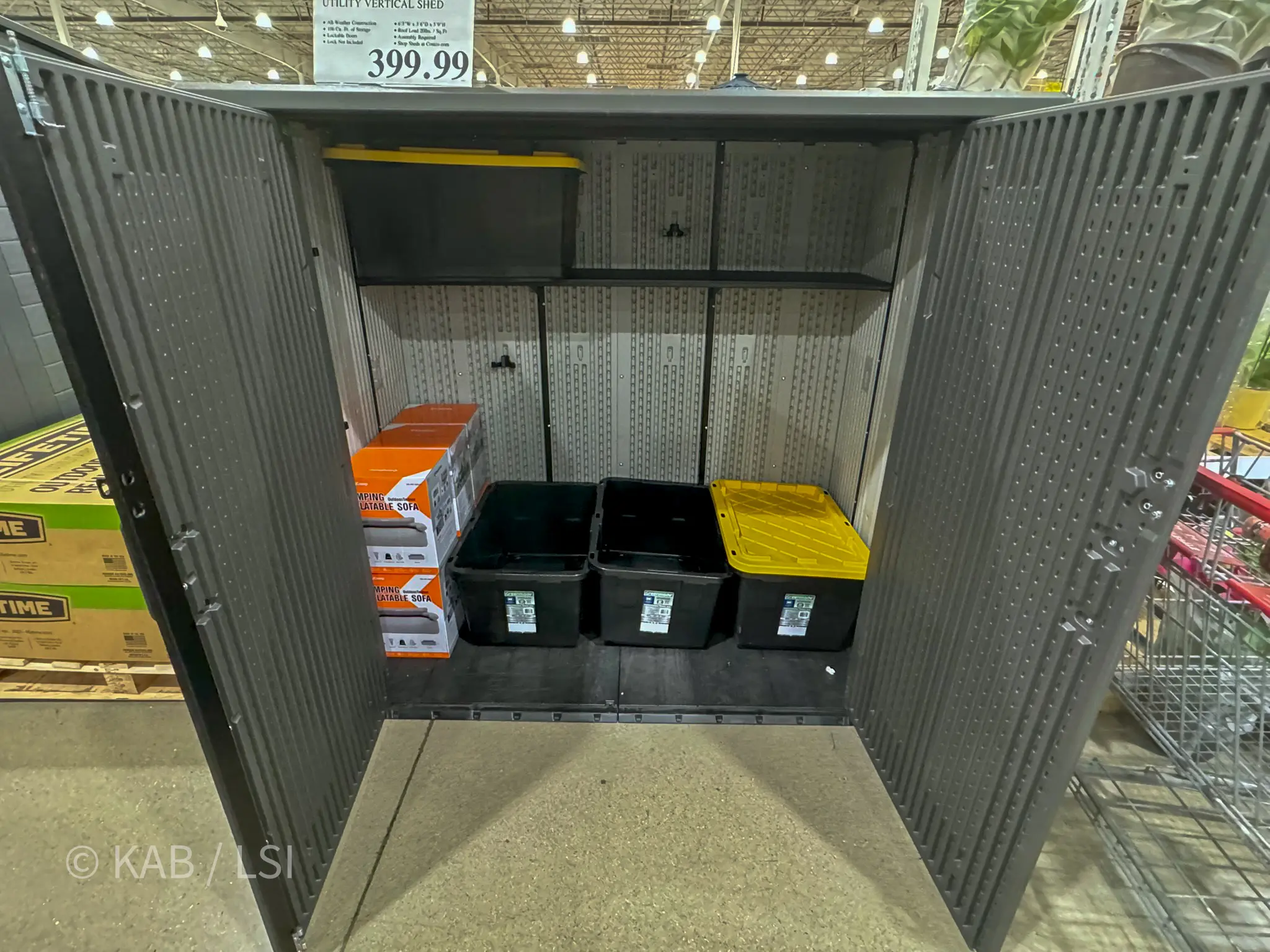 Open gray Costco Lifetime vertical utility shed with storage bins inside, photographed at the Costco store with its $399.99 price tag visible, shown as the standard Water House enclosure for one-acre La Habra Heights hillside properties