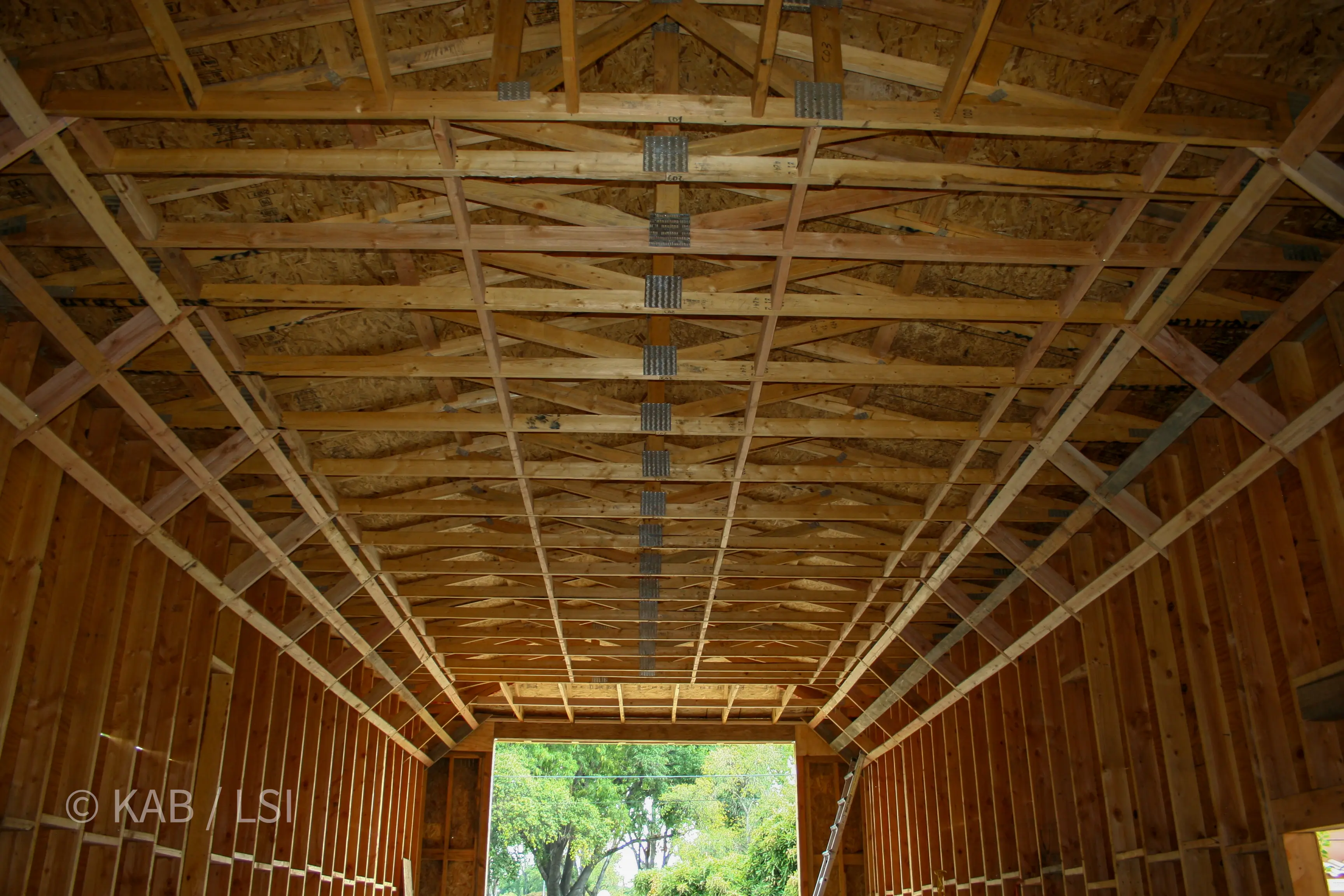 Engineered roof trusses with seismic diagonal bracing spanning the RV garage depth © KAB/LSI