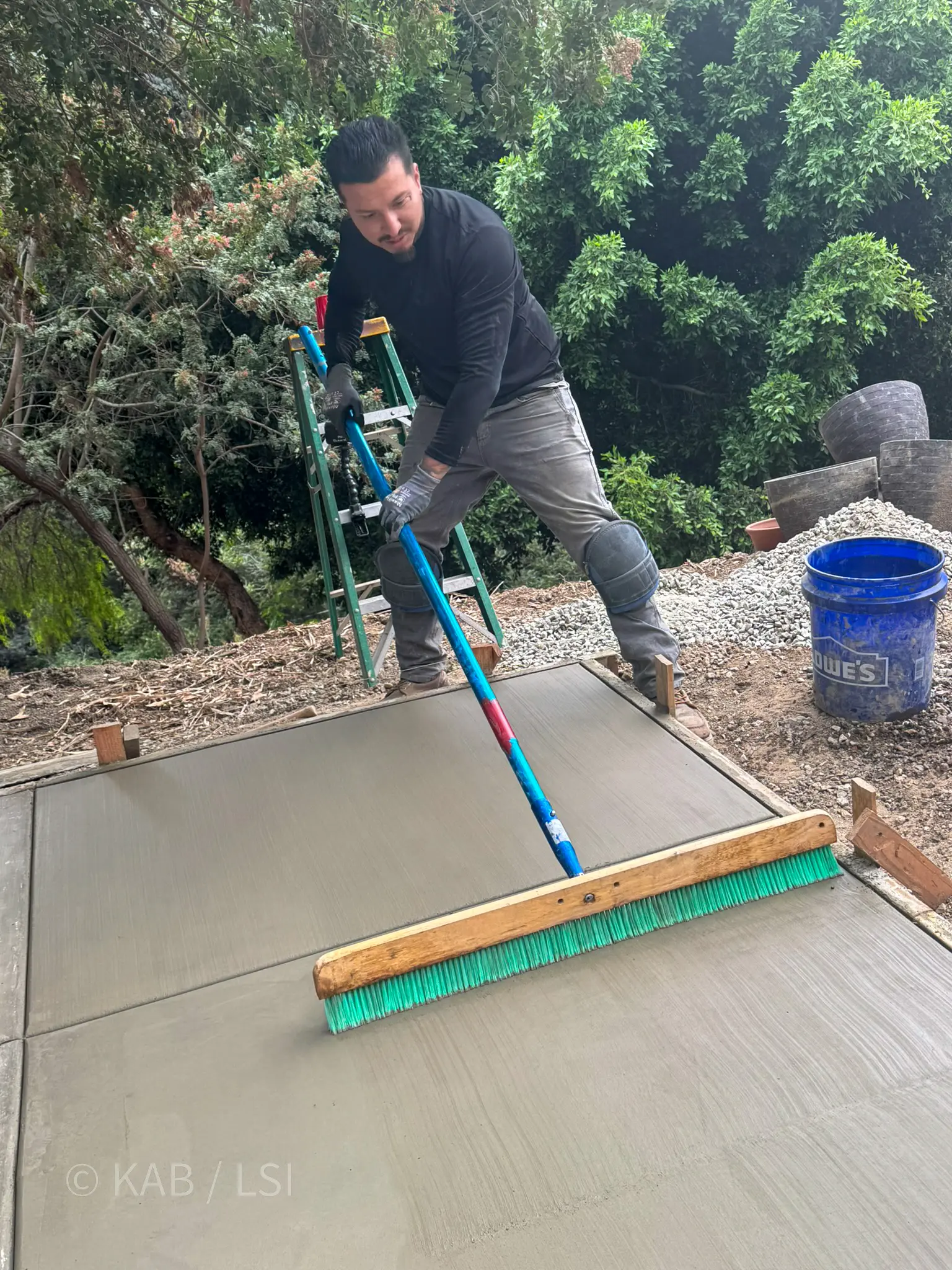 Jeff broom-finishing concrete at the exact moment it has set up