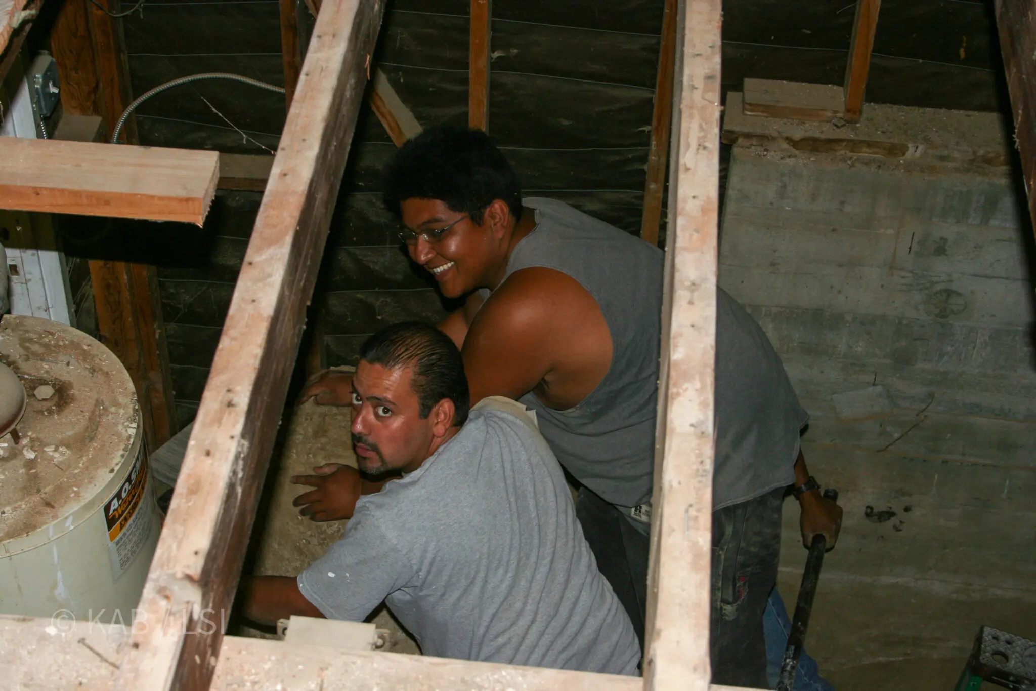 A smiling pastor working in the crawlspace under a La Habra Heights hillside home during the excavation that doubled the home’s square footage without expanding its footprint