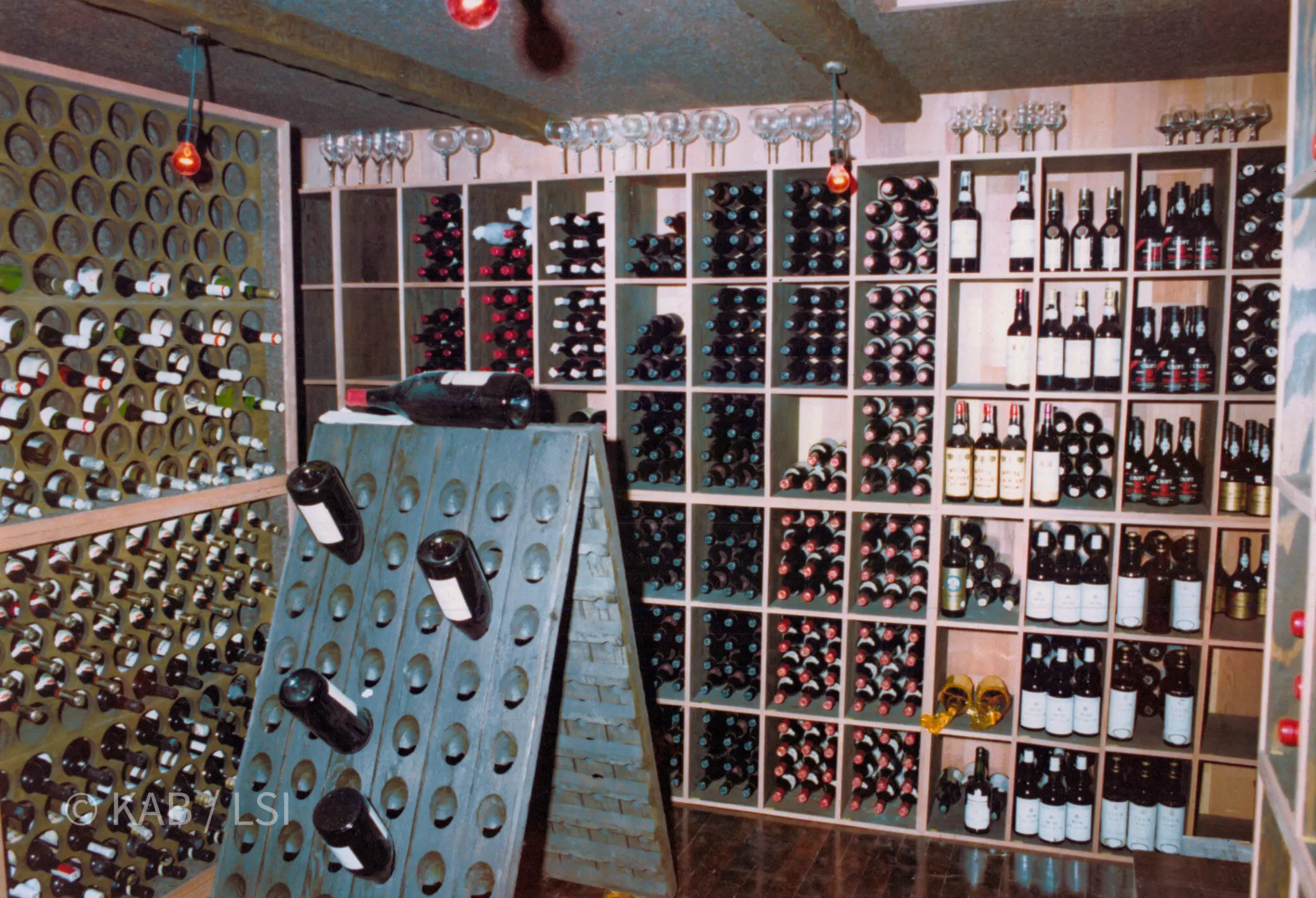 Corner of a 6,000-bottle Hollywood Hills cellar — riddling rack, polyurethane circular-bore island rack, redwood-faced modular walls