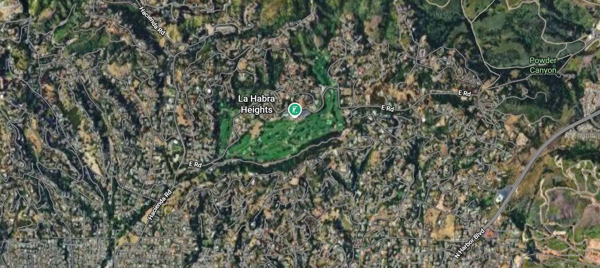 Satellite view of La Habra Heights showing winding roads, no street grid, and the green of the Hacienda Golf Club at the center