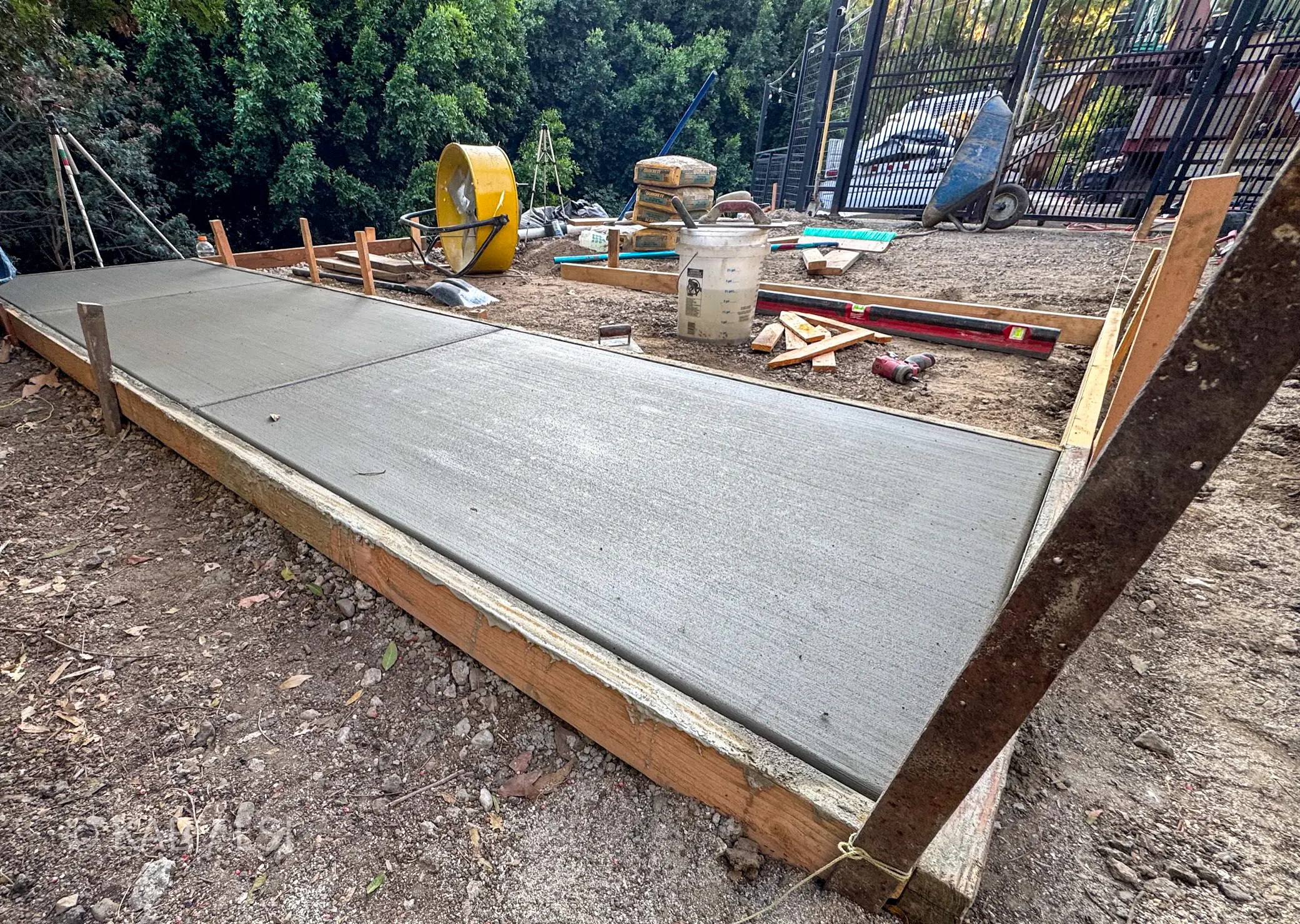 Completed concrete pad in timber forms on a hillside lot with the canyon visible beyond