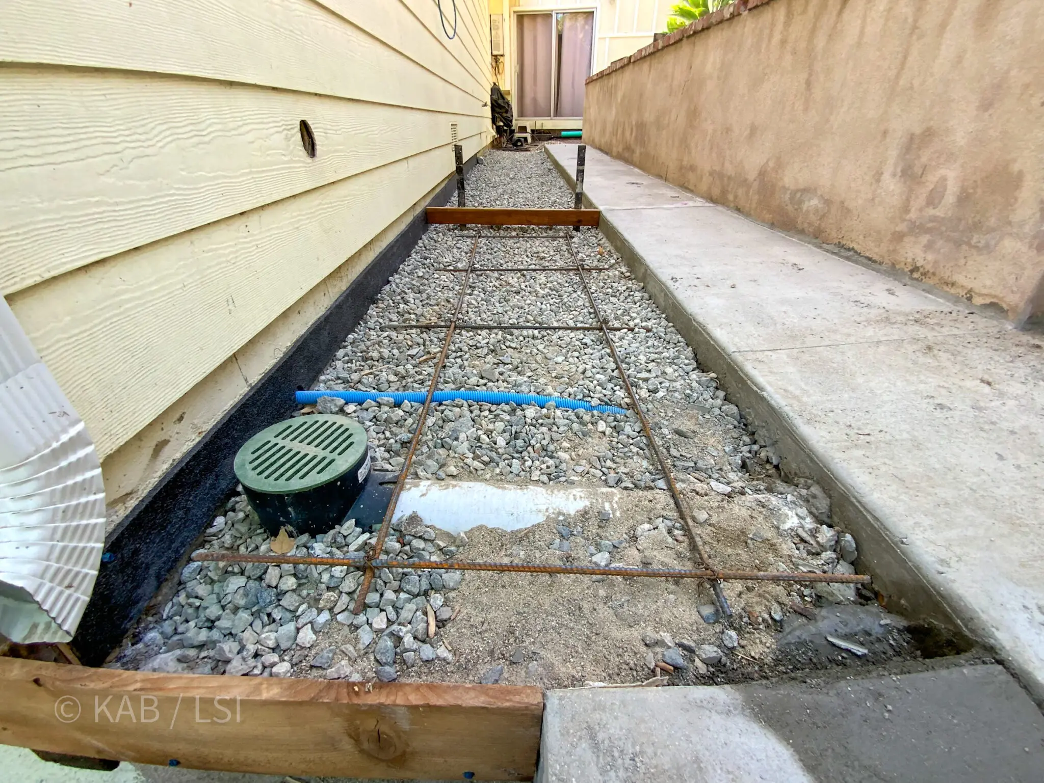 Re-poured concrete walkway with new drainage behind a La Habra Heights hillside home