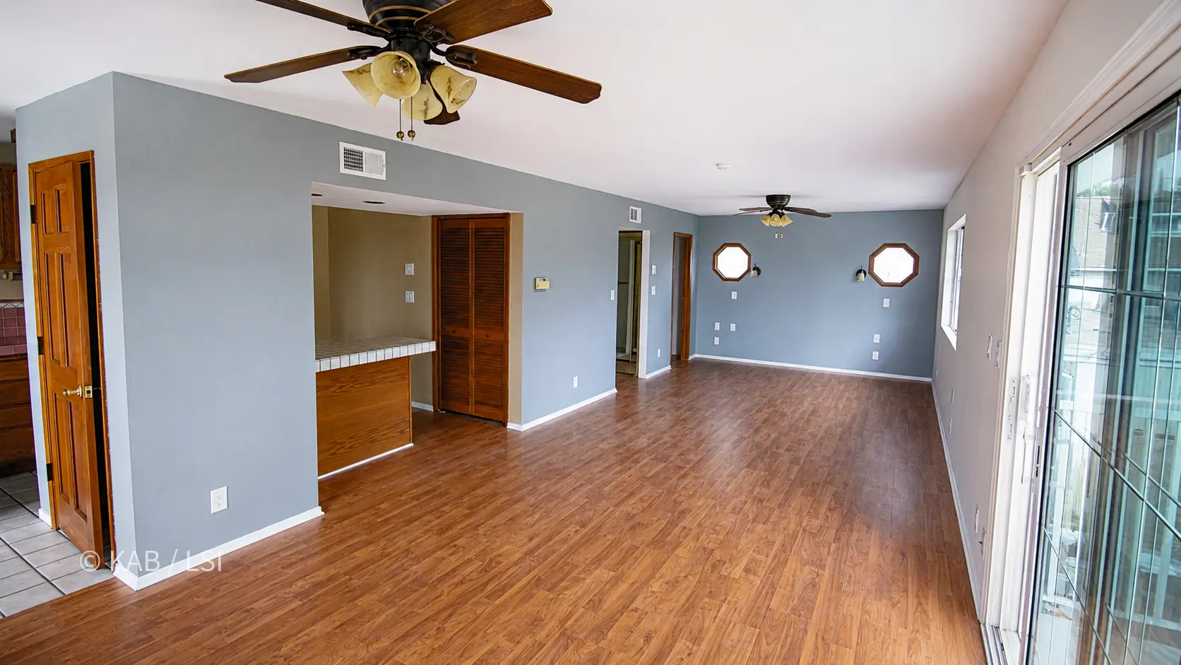 The ADU great room with hardwood floors, the kitchen at one side and a sliding door to the patio.
