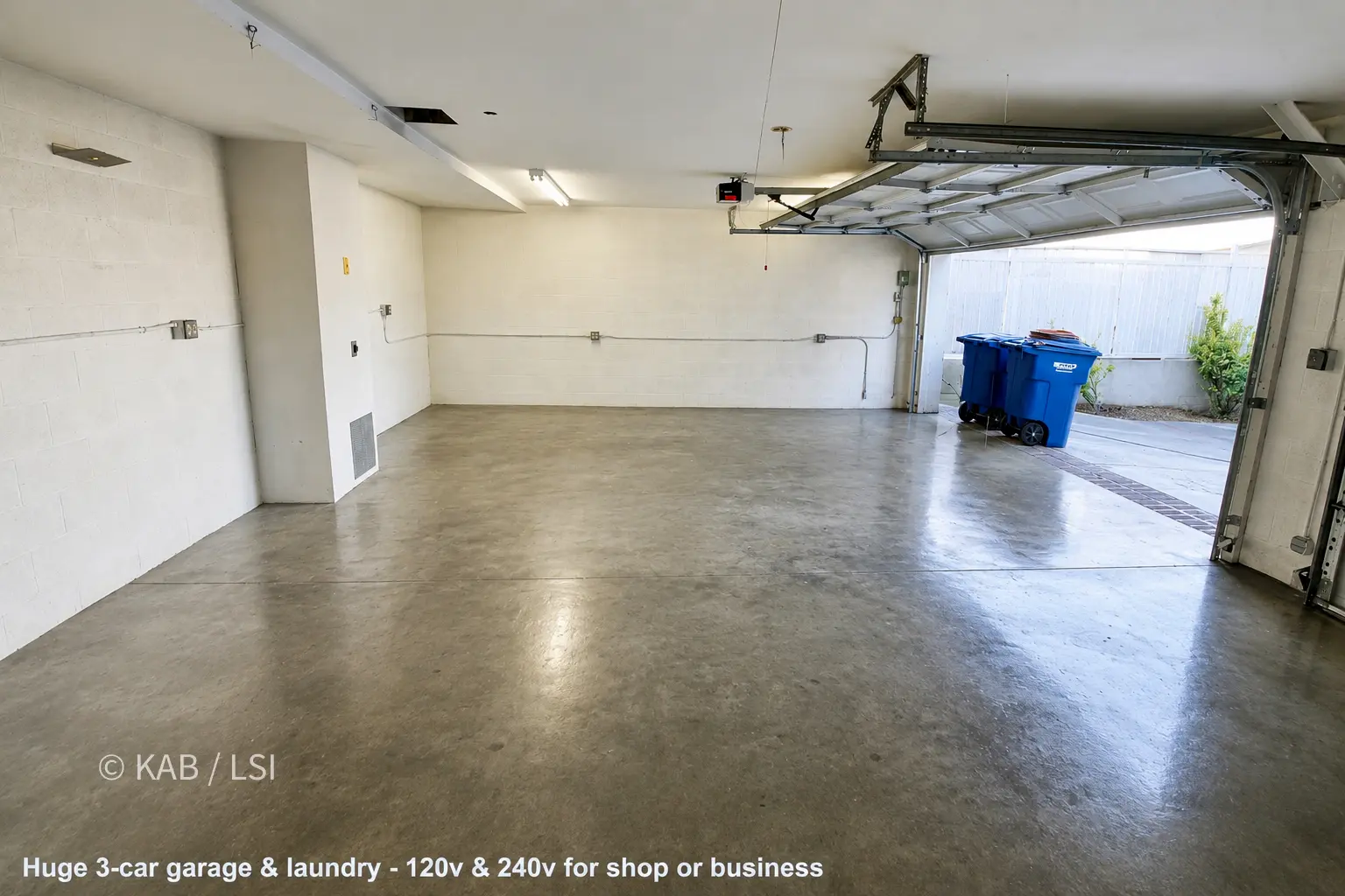 Interior of the three-car garage built into the hillside cut, with twelve-inch concrete-block walls.