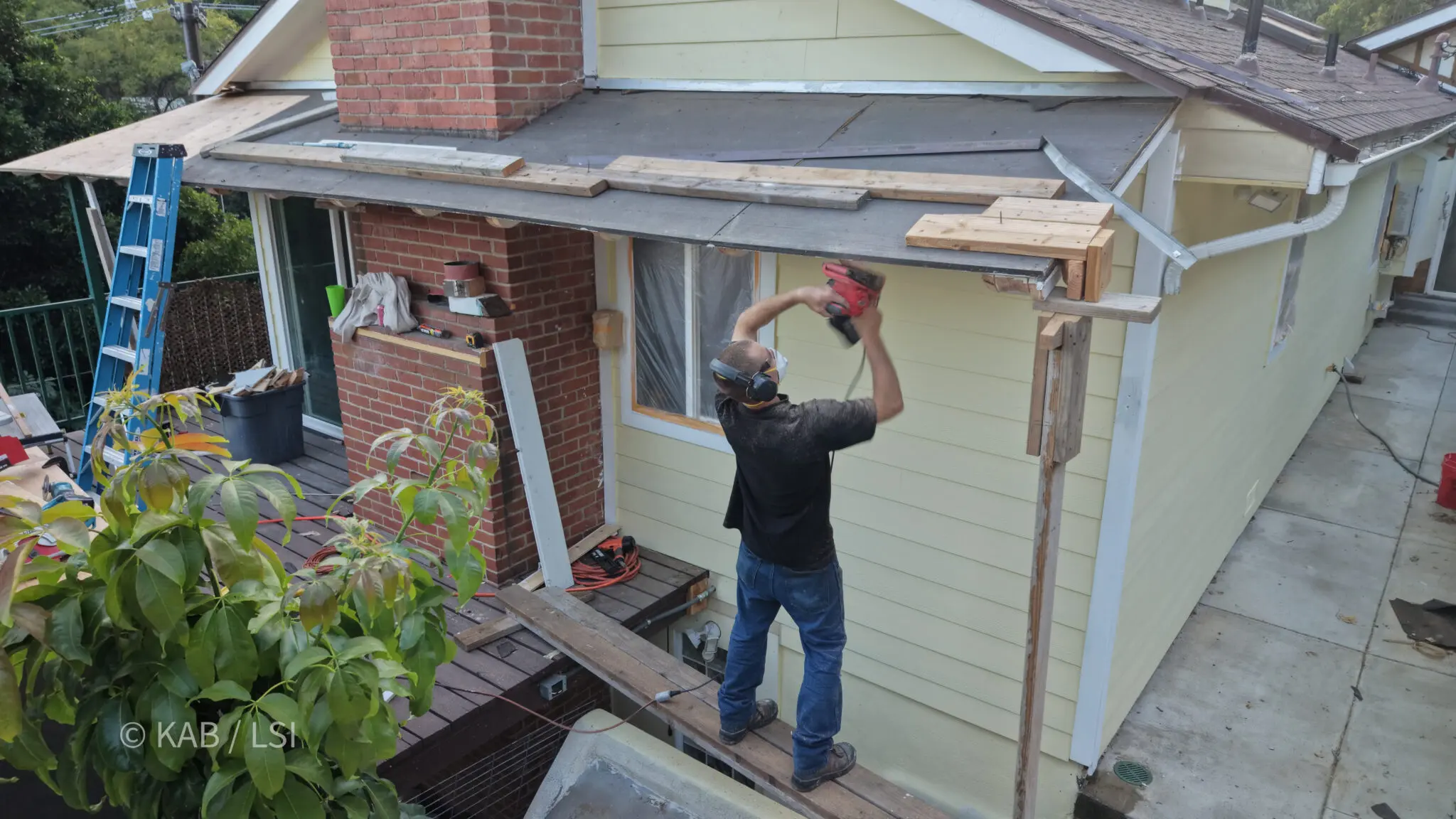 Shaping rebuilt rafter tails for long-term weather protection on a hillside home
