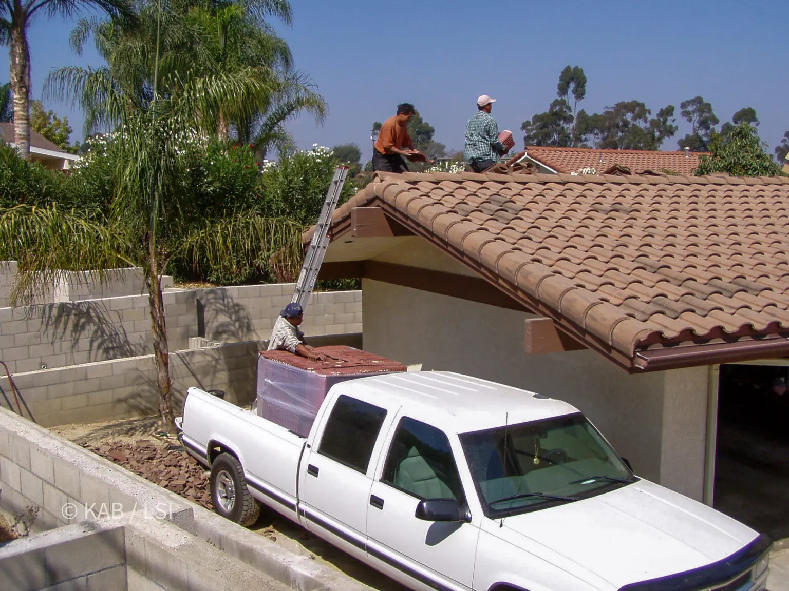 Pallet of new concrete roof tile delivered by pickup truck to a hillside home for a matched roof repair