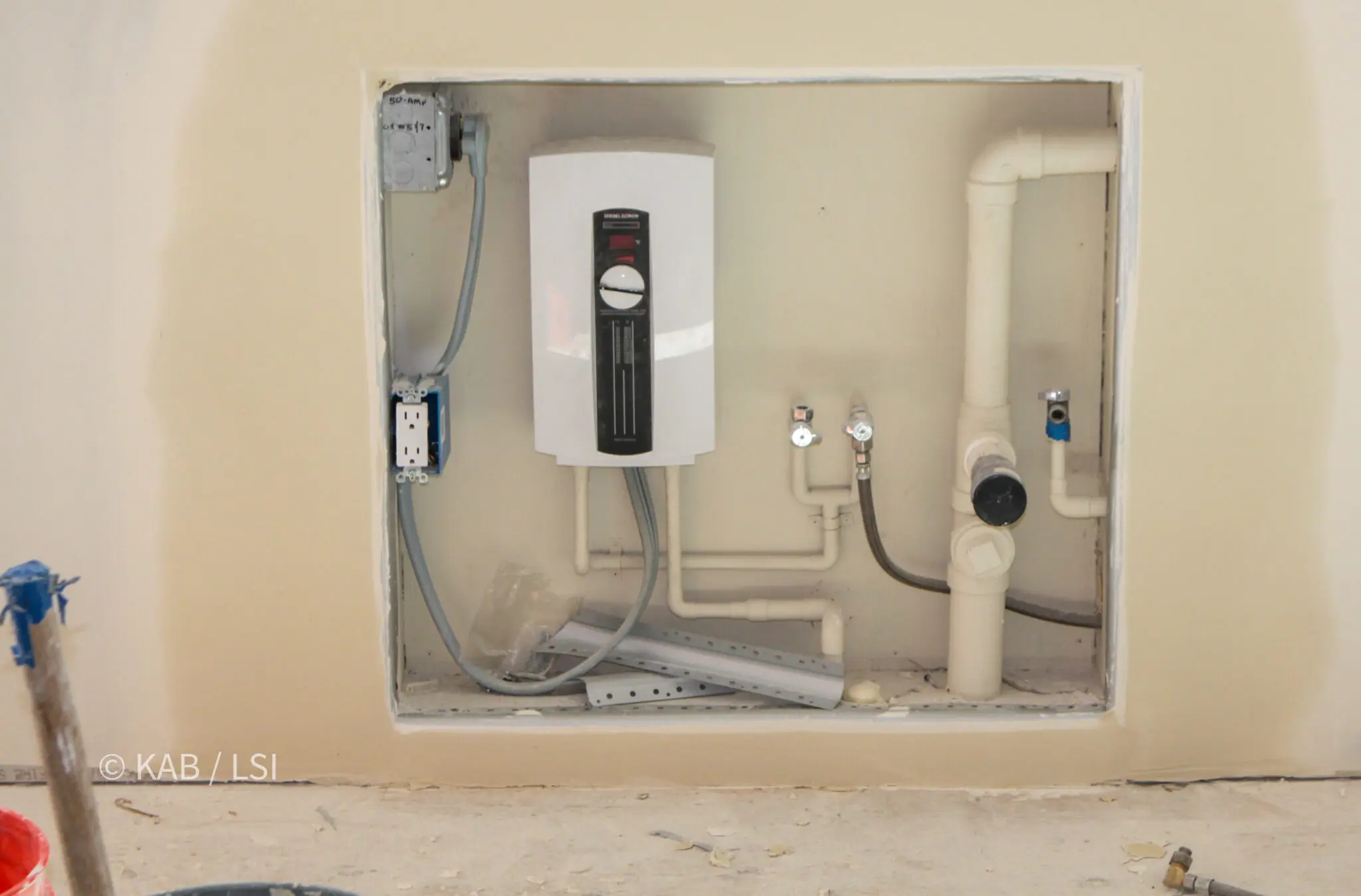 Point-of-use electric instant hot water heater installed beneath a kitchen sink to serve the sink and dishwasher