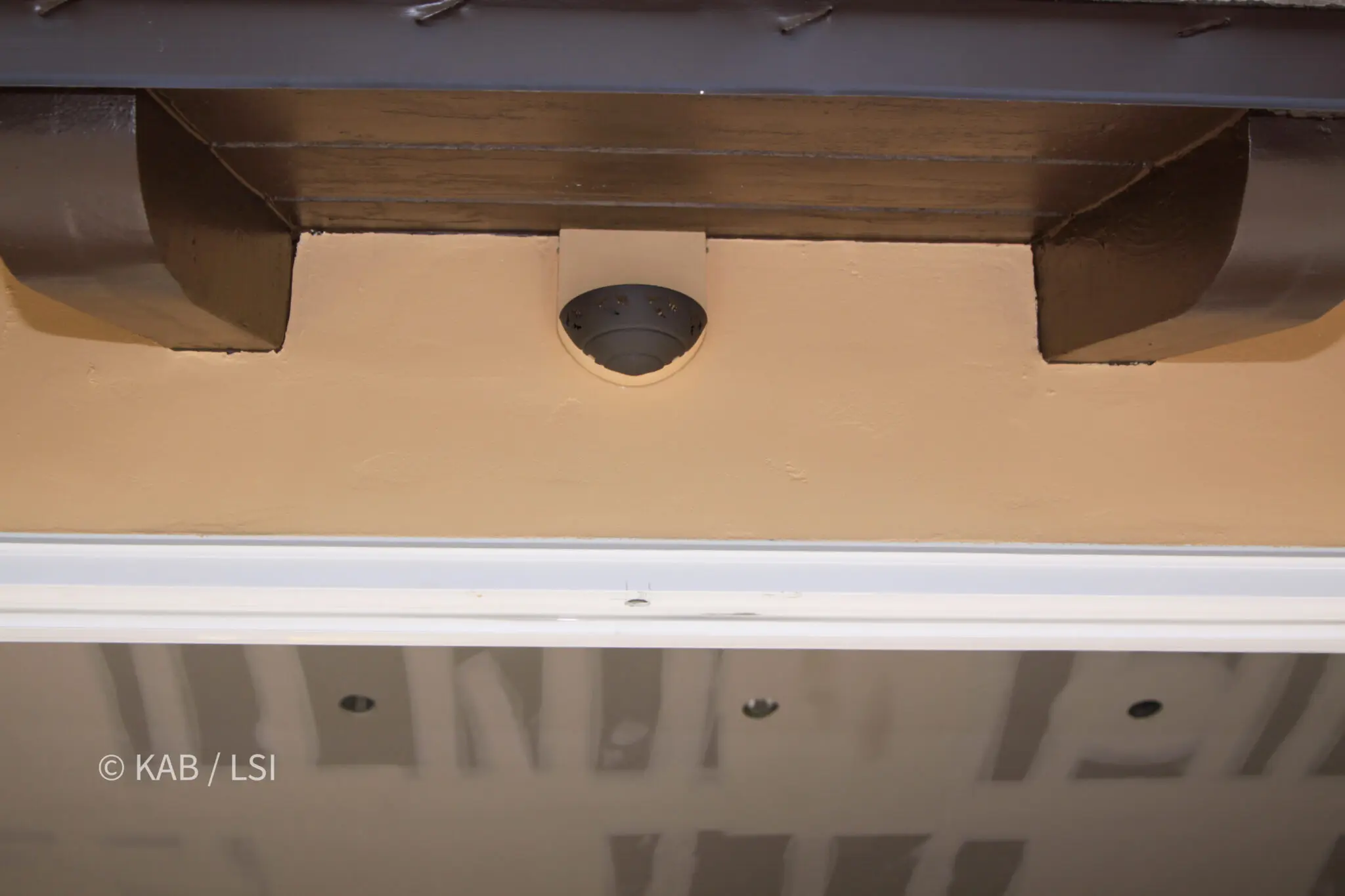 Recessed dome light fitted into the underside of a timber eave above a doorway