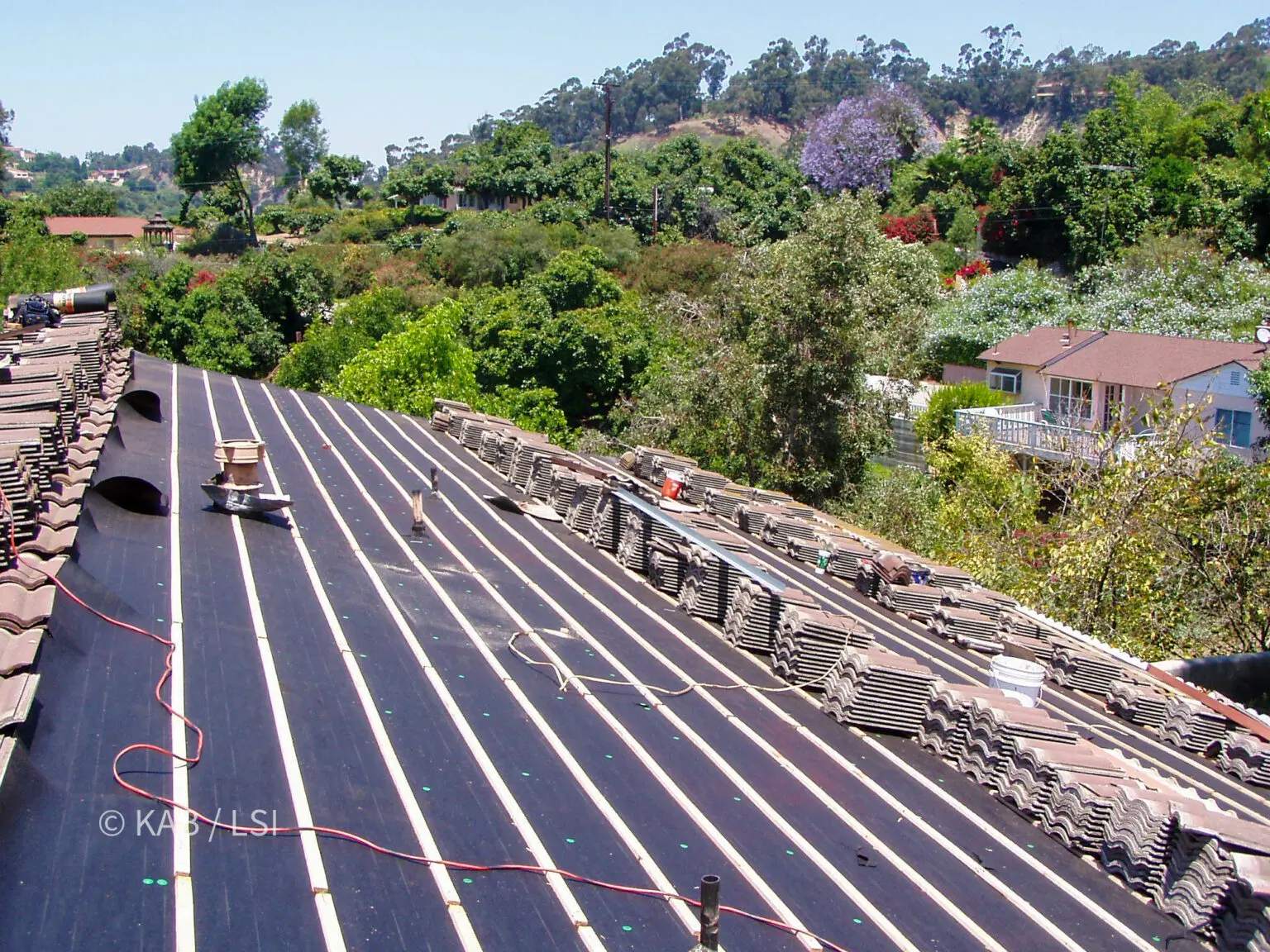 Roof deck resheeted in plywood with new felt underlayment and one-by-two battens installed before concrete tile is reset