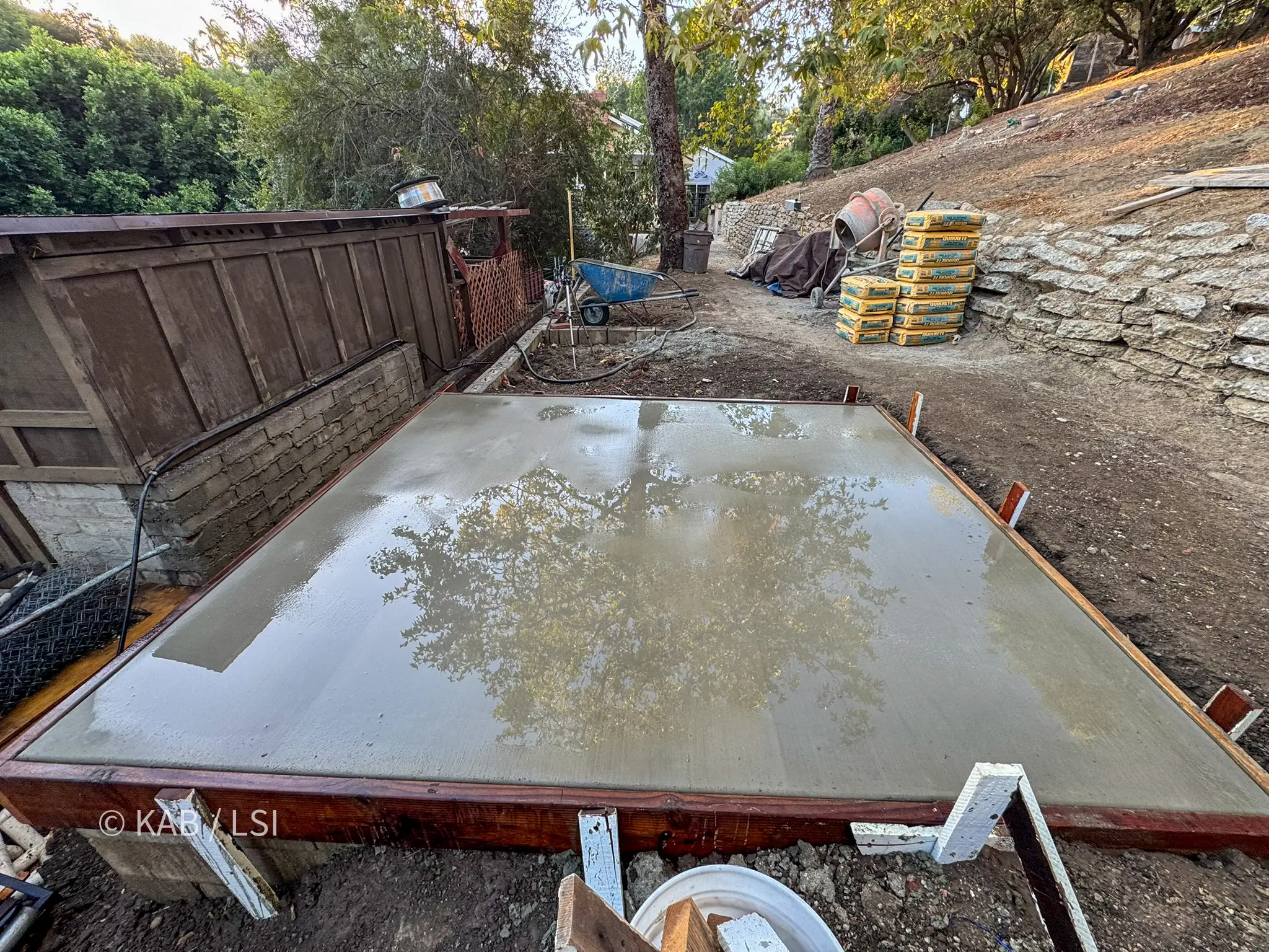 Finished reinforced concrete pad poured for a storage shed on a leveled hillside terrace