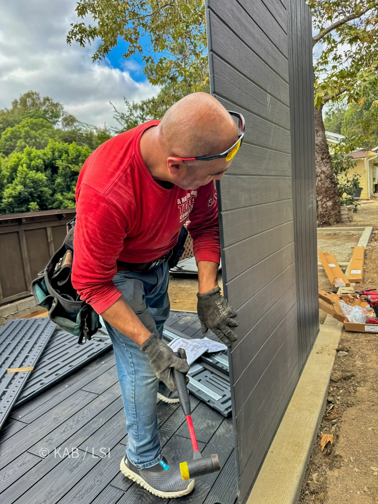 First wall panel of a Lifetime storage shed raised on a concrete foundation