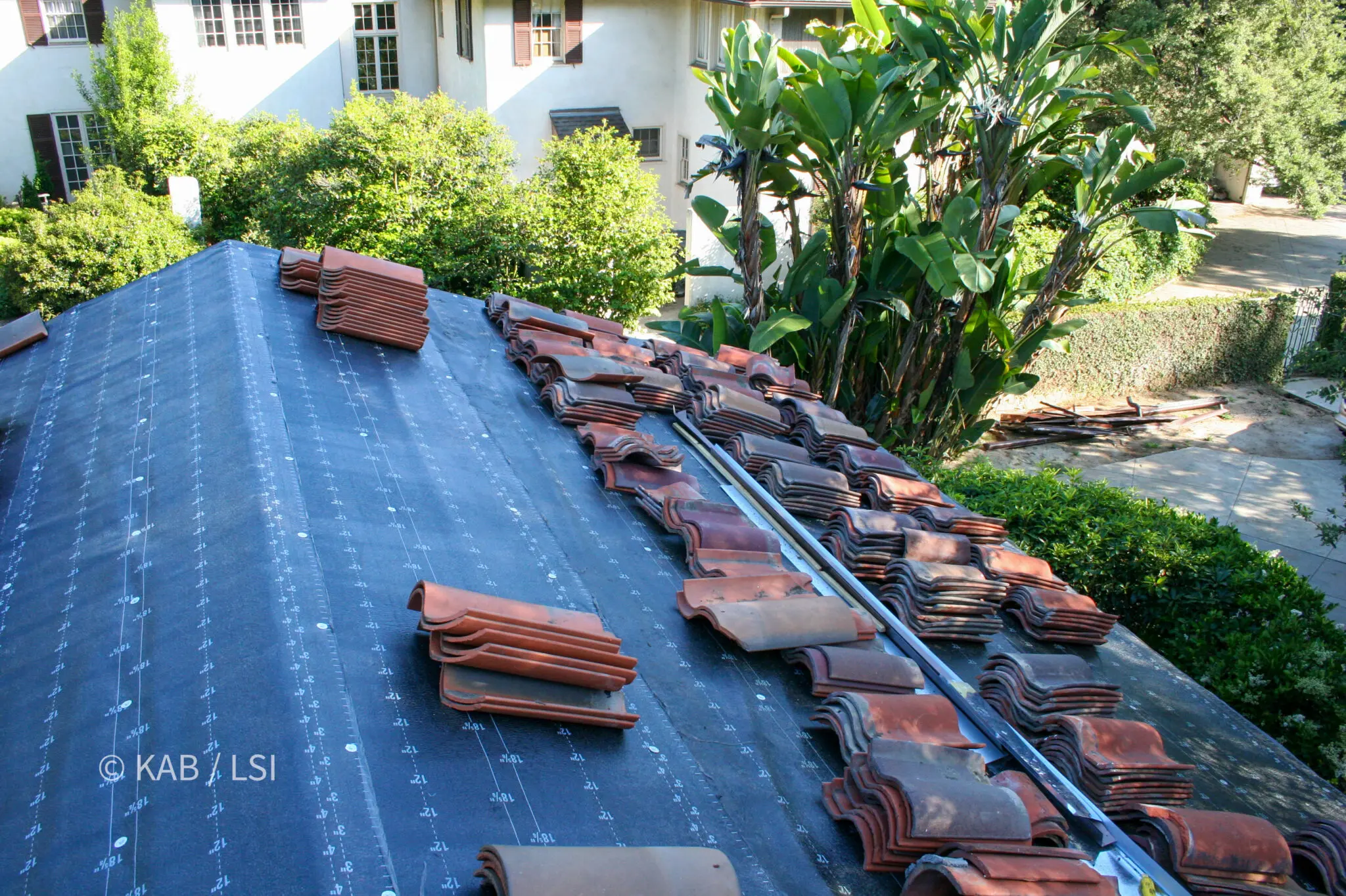 New underlayment installed over the original sheathing with historic clay tile stacked ready to be reset
