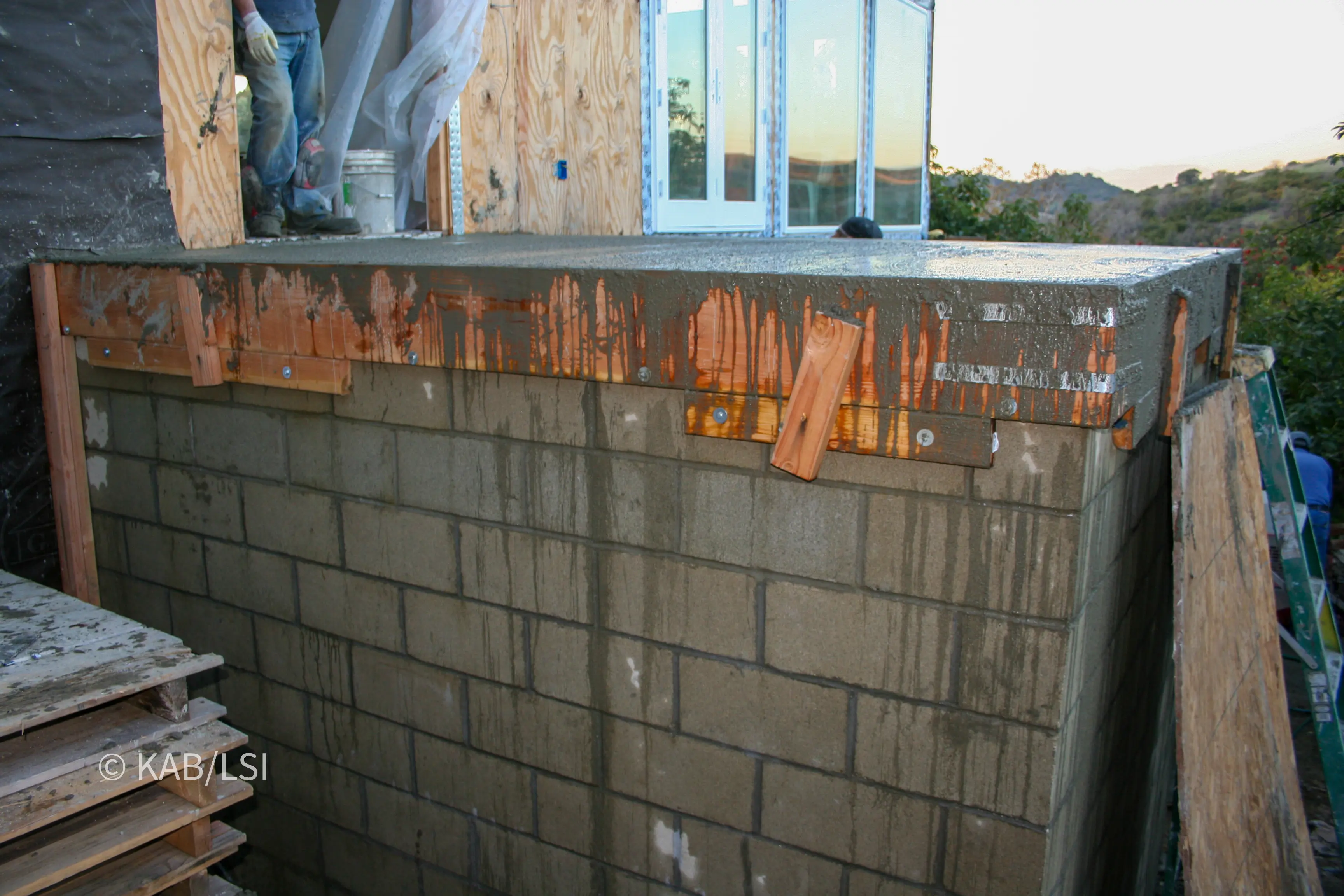 Poured concrete lid capping a concrete block safe room, forming the structural landing of a house entry