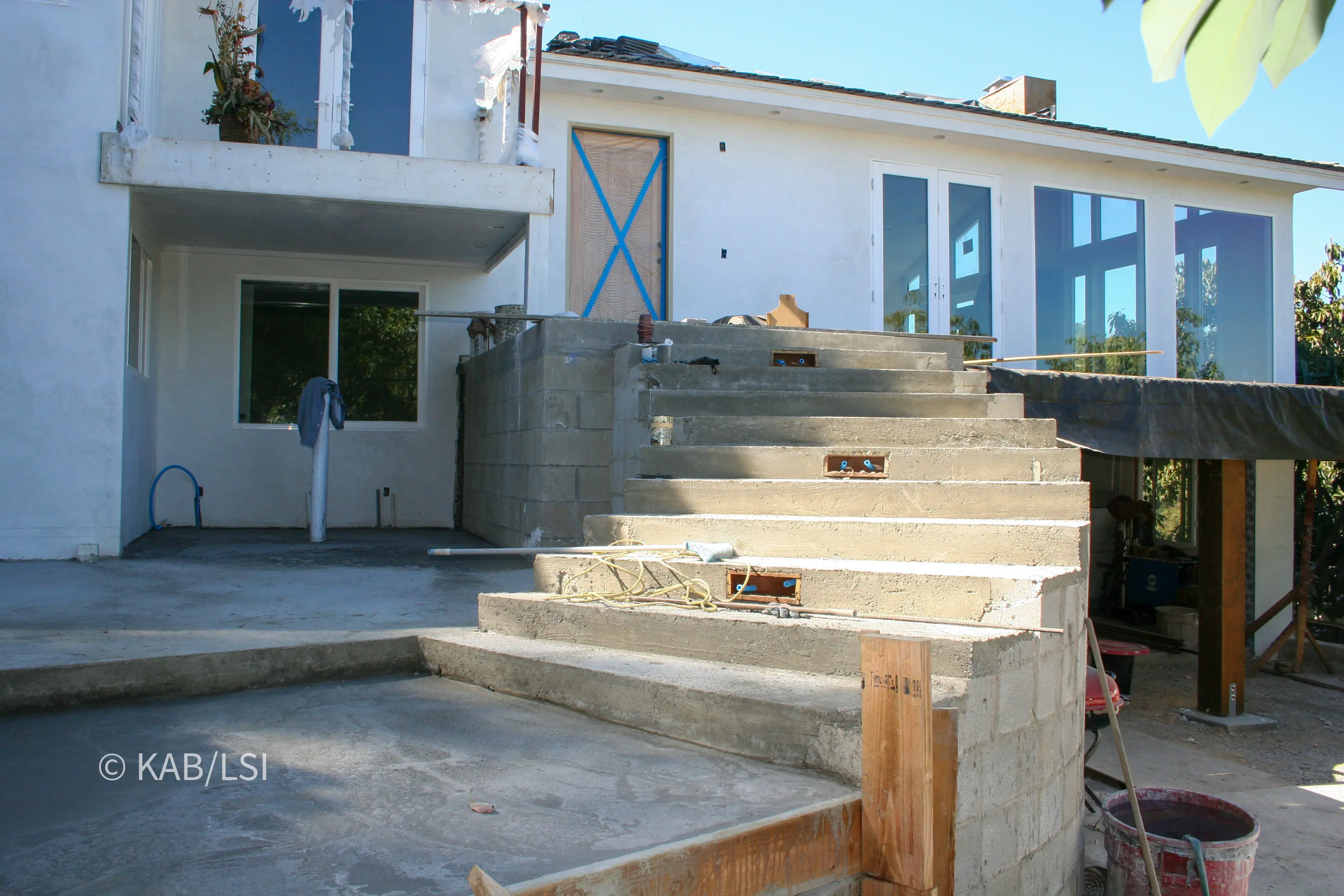 Integrated safe room and home office entrance during construction of a hillside home