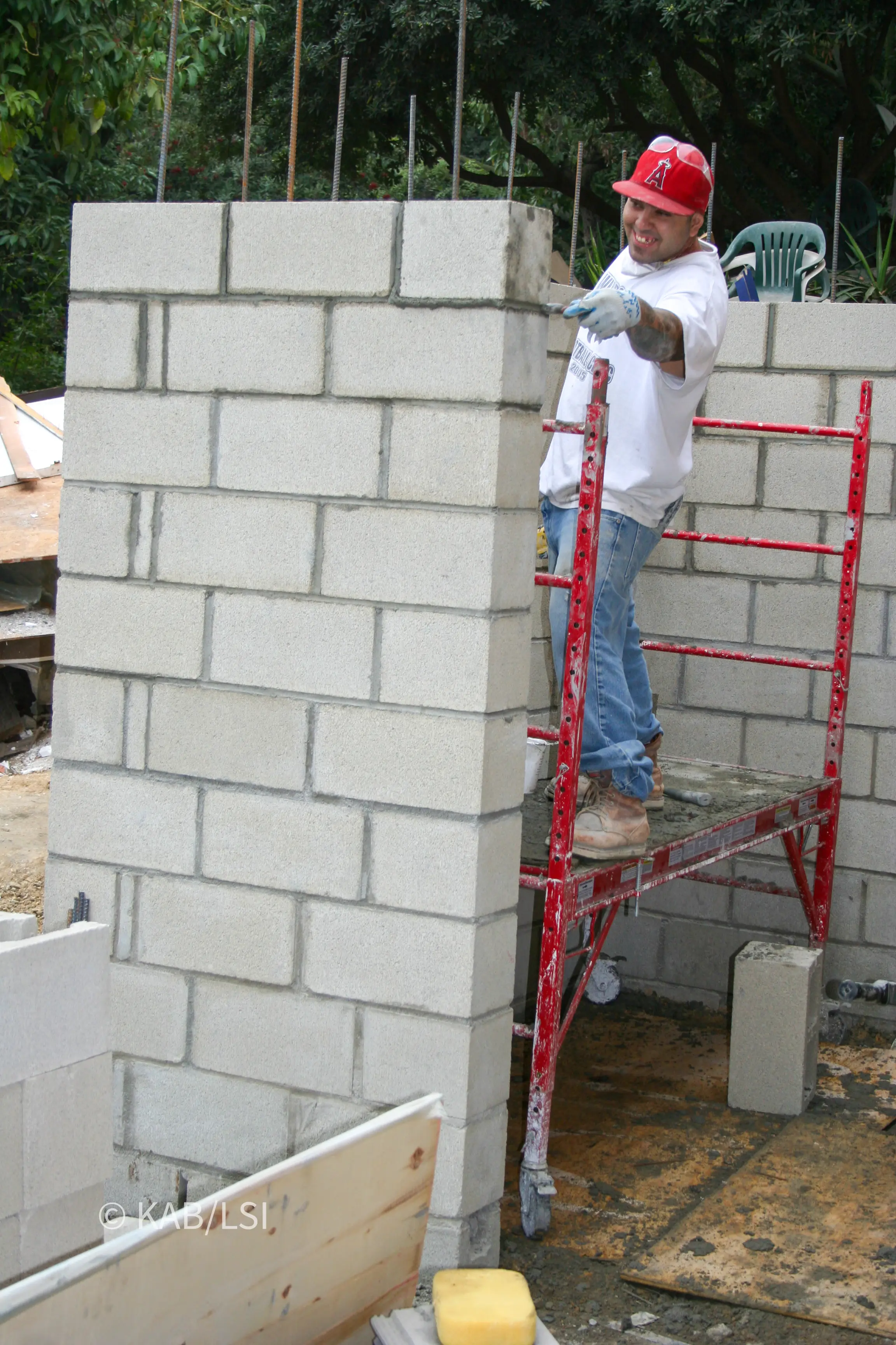 Concrete block walls rising over vertical reinforcing steel during construction of a hillside safe room