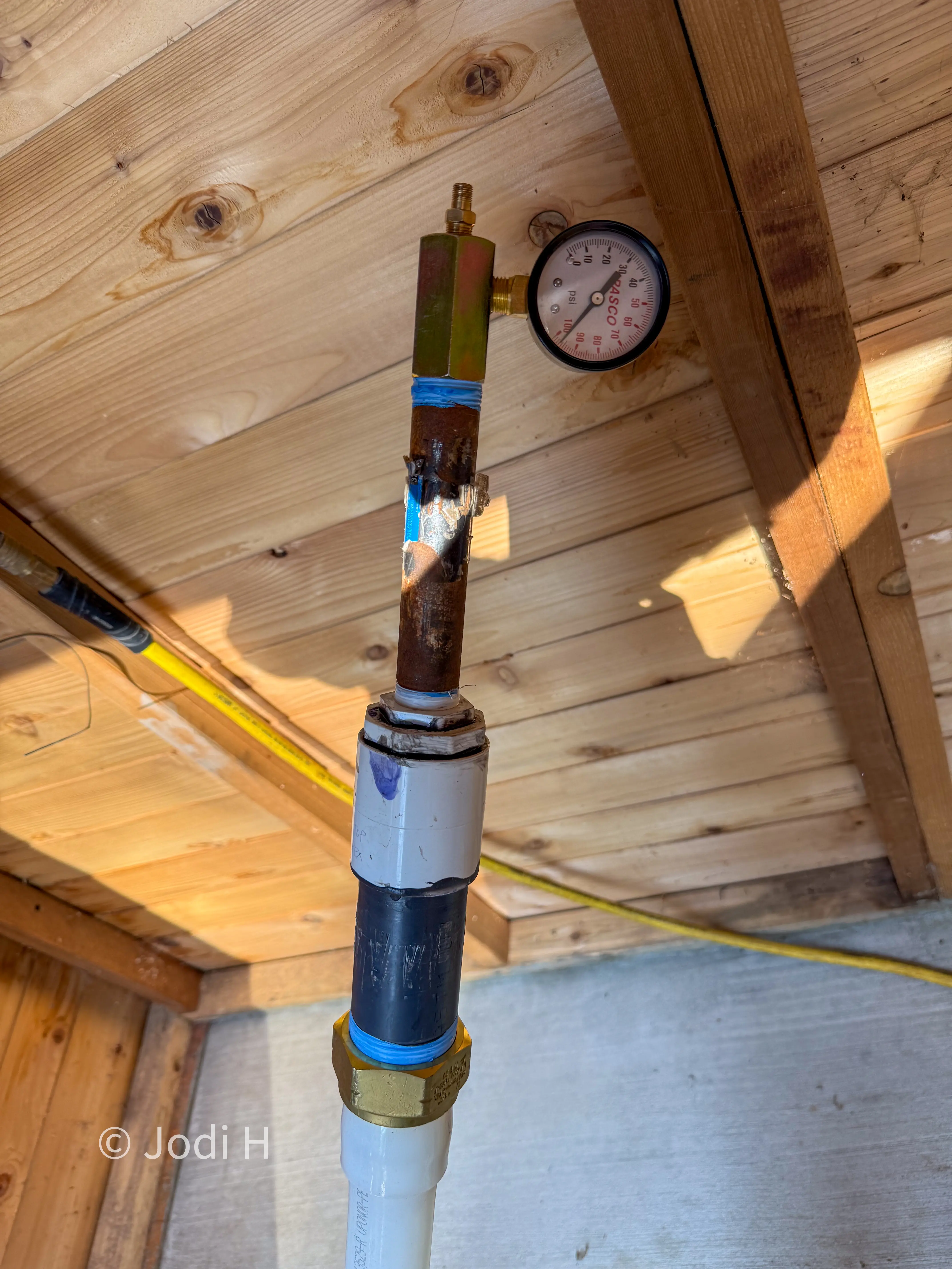 Temporary pressure test gauge on the PVC water service line before the trench was backfilled