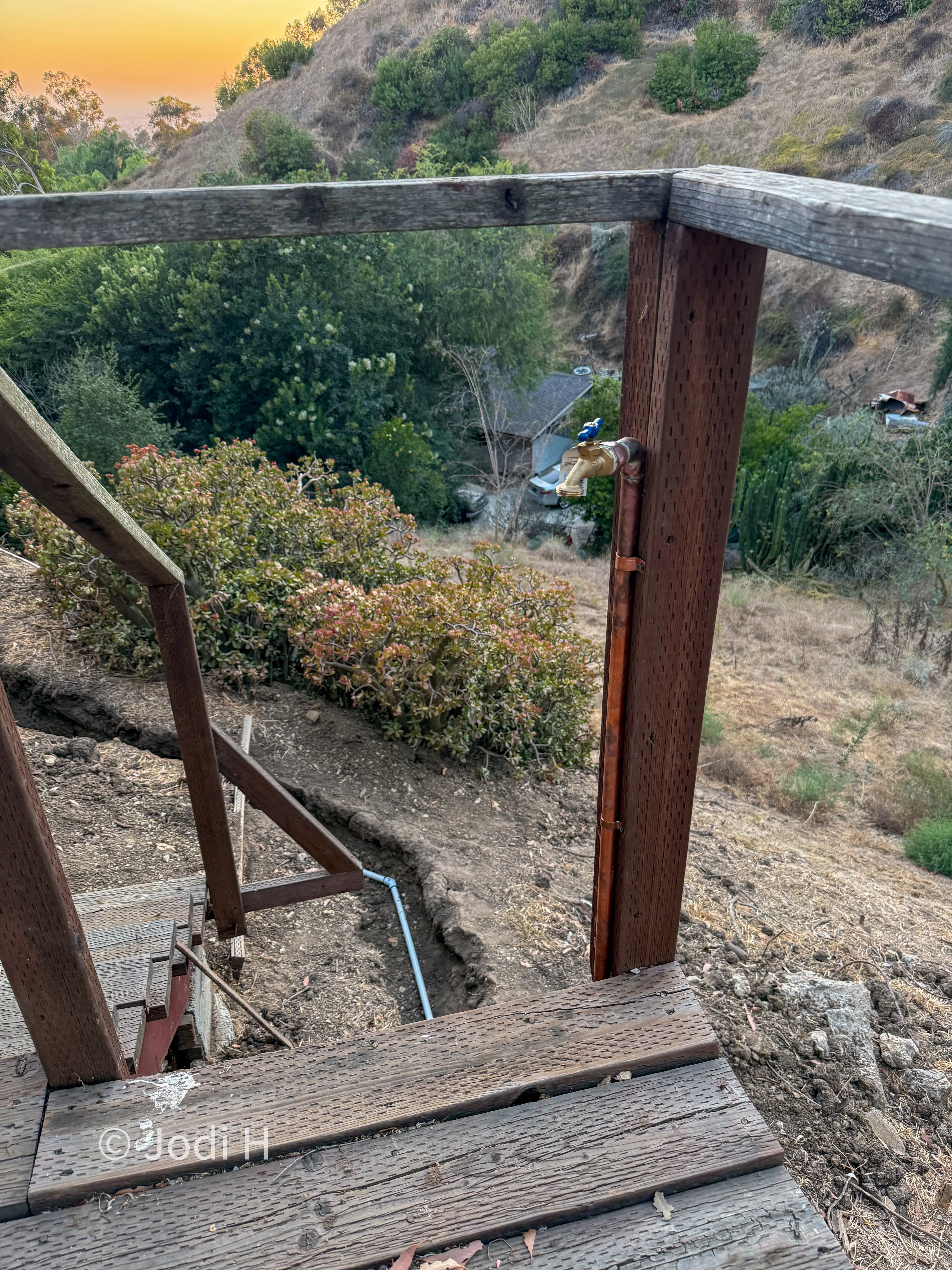 Water riser and hose bib installed at a hillside staircase for wildfire defense access