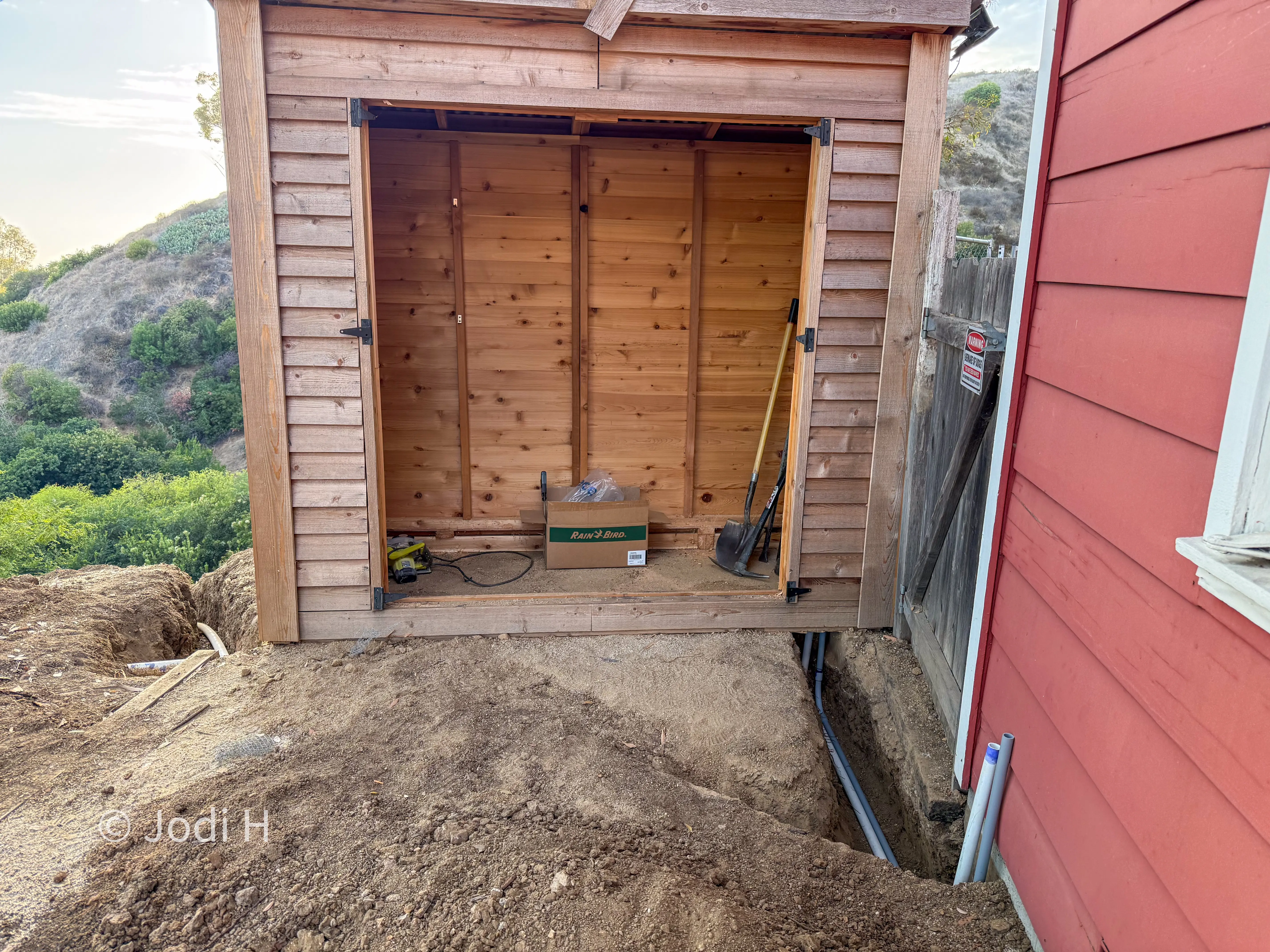 Cedar shed converted into a water equipment building beside a hillside home on a hillside property in La Habra Heights