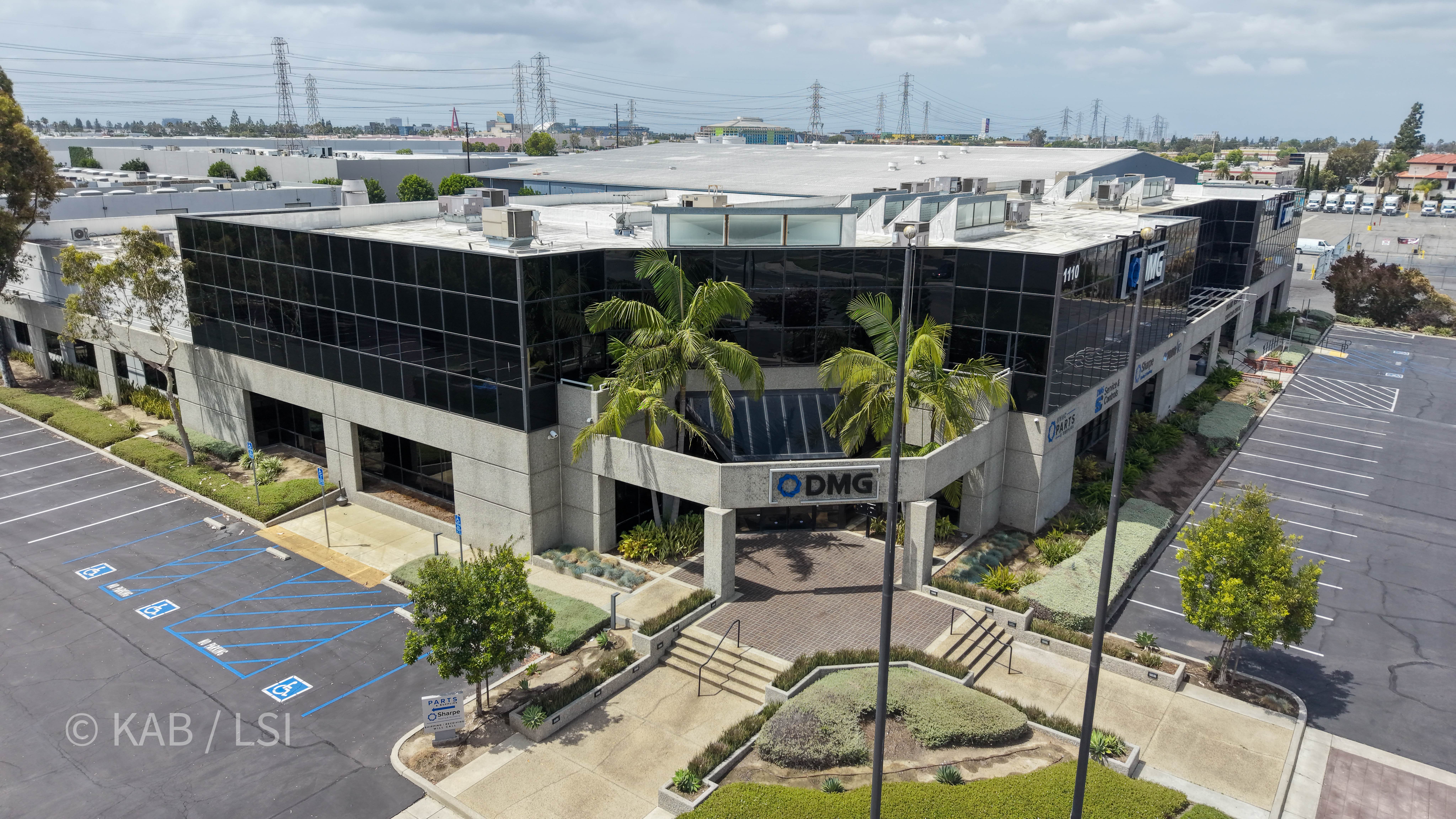 Aerial view of the front entry of the 88,000 sq ft commercial building at 1110 W. Taft Ave., Orange, CA, with DMG HVAC signage above the entrance and the full manufacturing footprint visible behind the office wing.