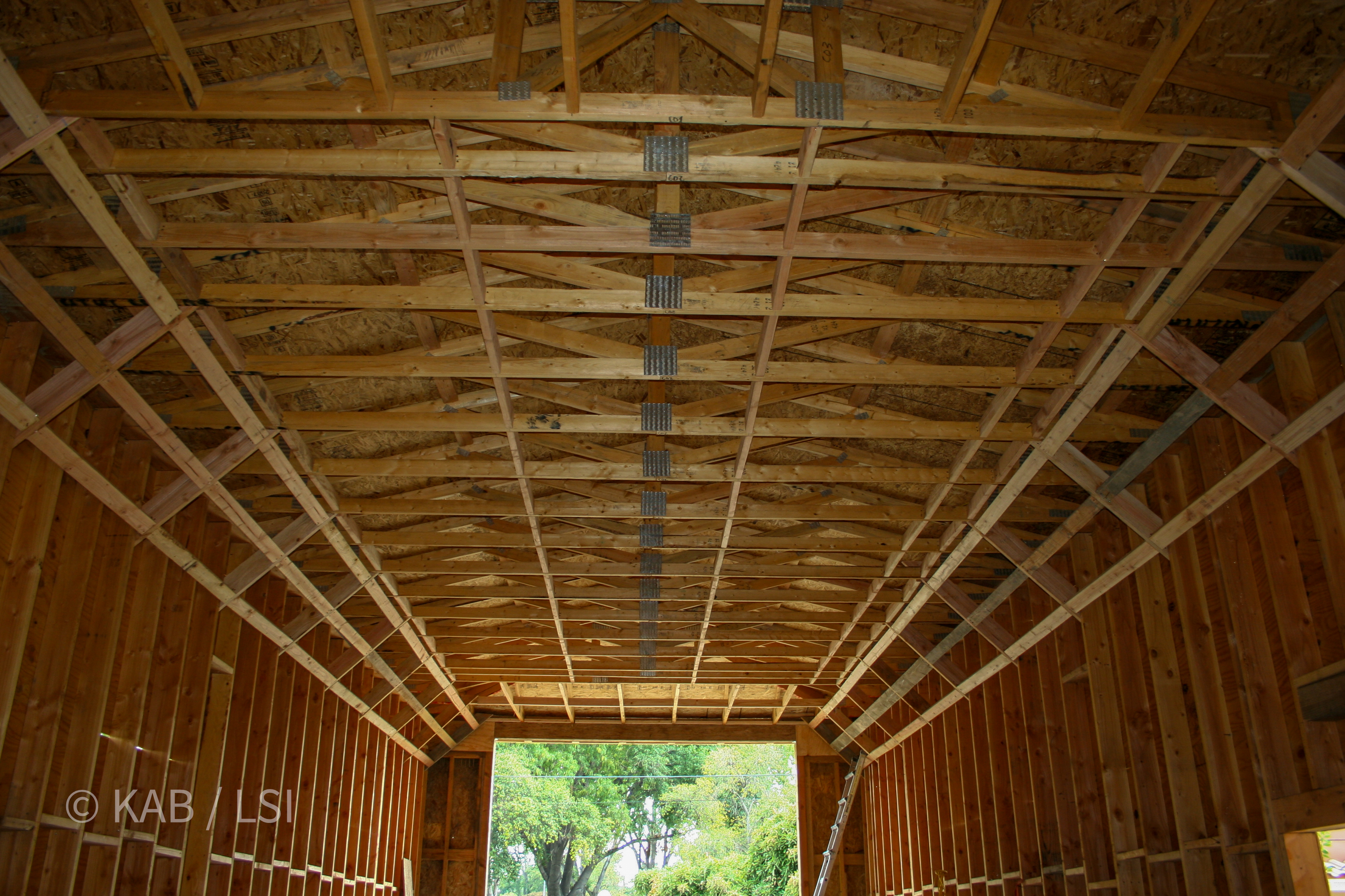 Engineered roof trusses with seismic diagonal bracing spanning the RV garage depth © KAB/LSI