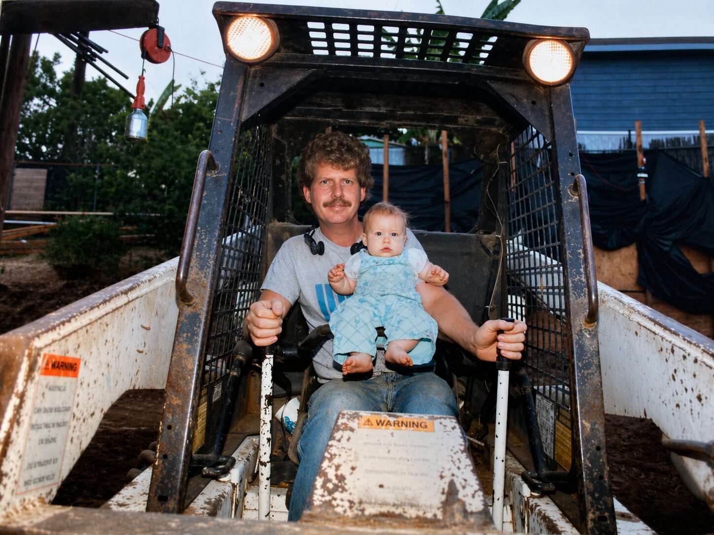 Keith Bennett in 1988 seated in a skid steer holding his infant daughter Megan on his lap on a La Mirada construction site.