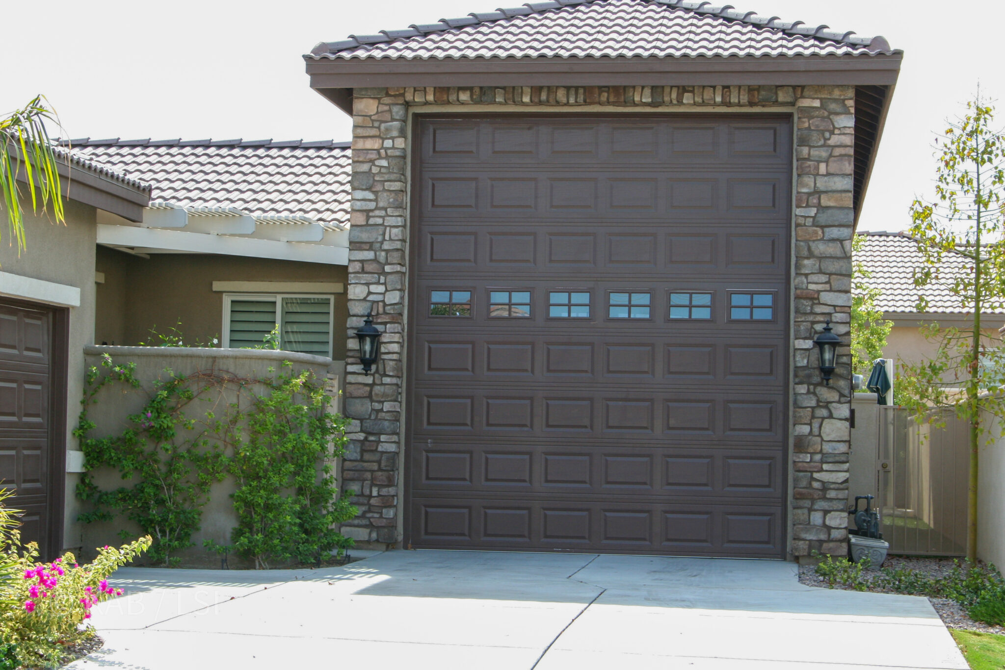 Class A RV garage integrated into home front elevation with stone cladding