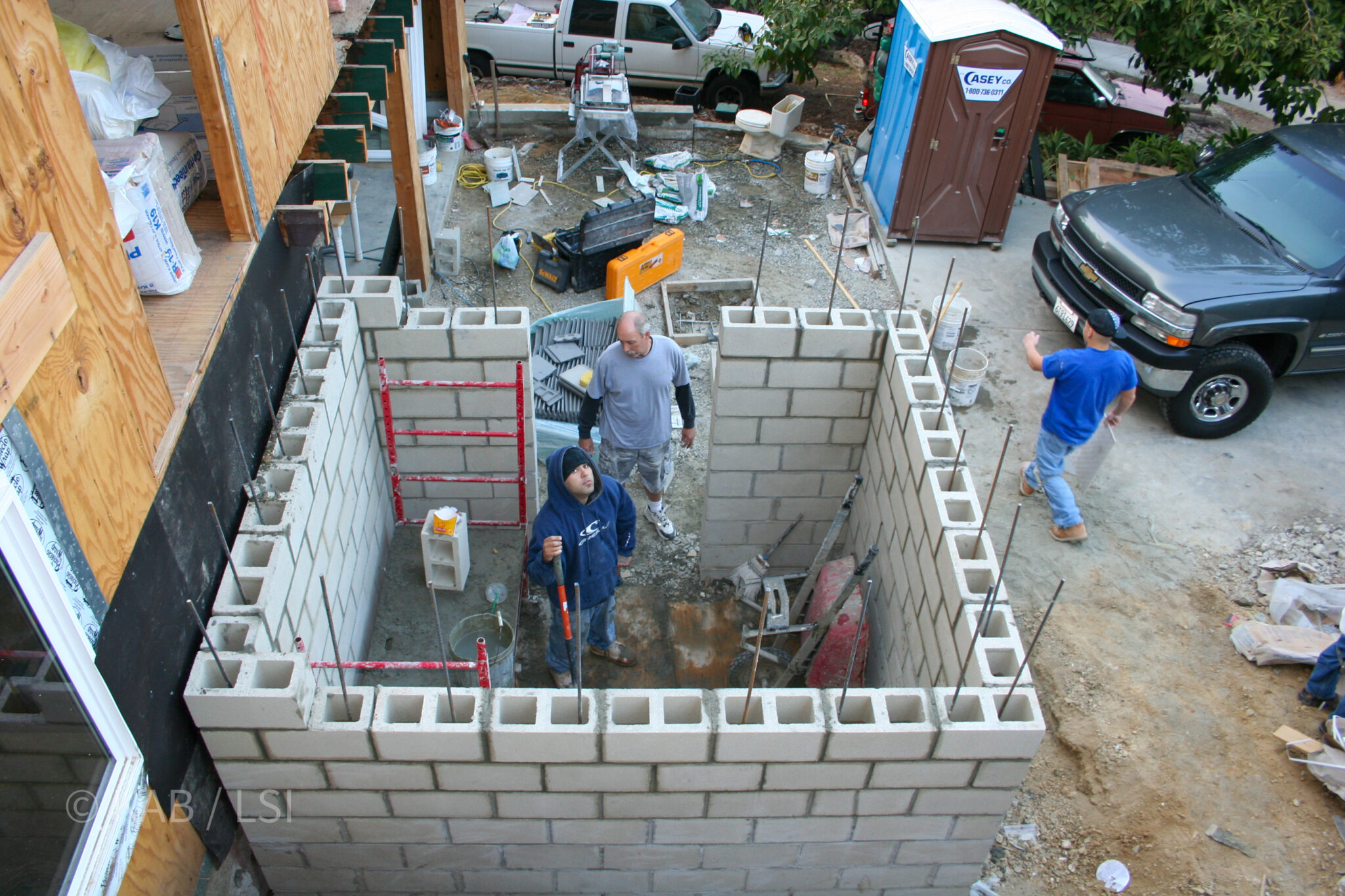 Safe room under construction — CMU block, mason and foreman © KAB/LSI