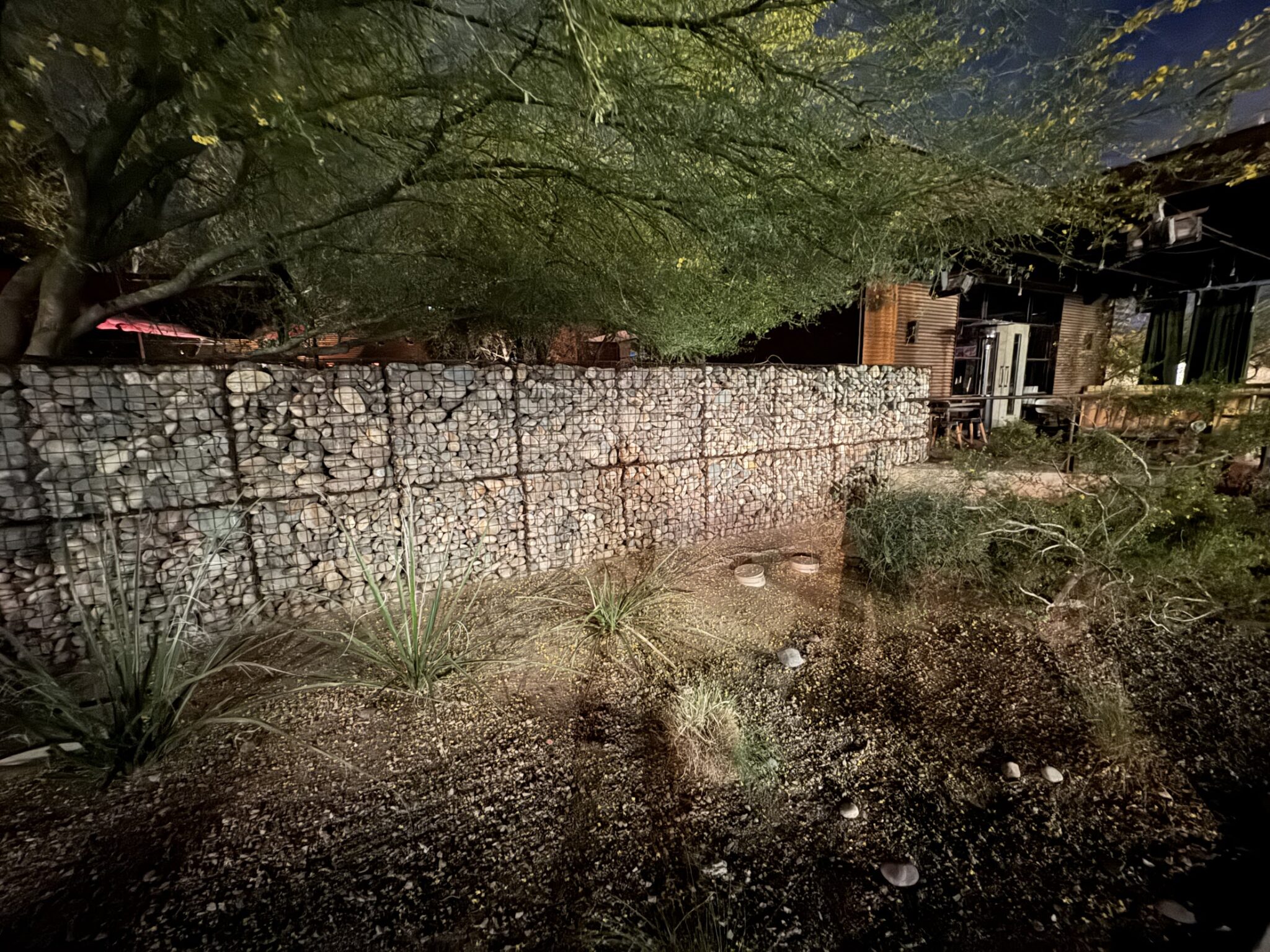 Gabion basket retaining wall with wire cages filled with stone holding back a Southern California hillside