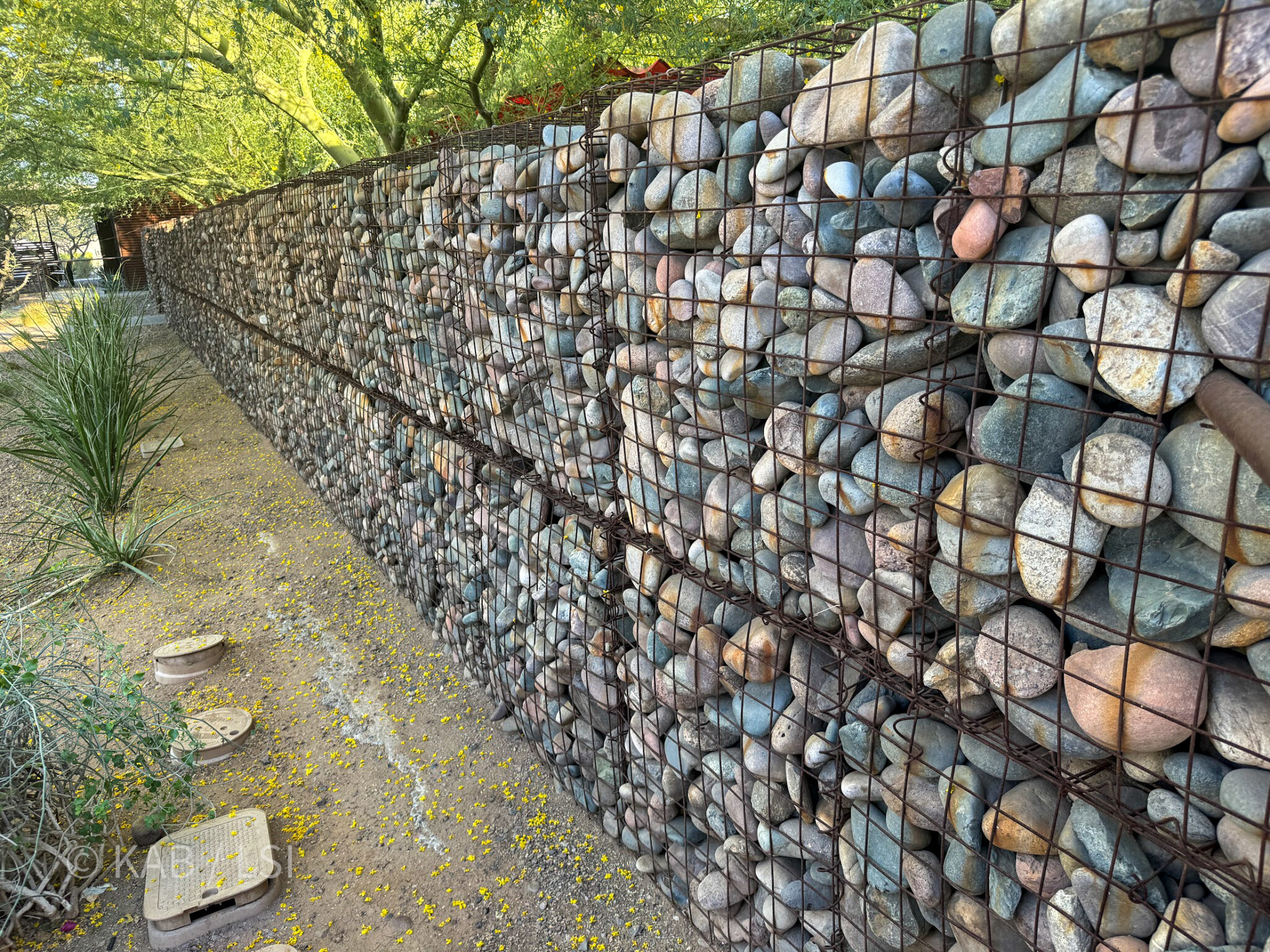 Close up of gabion basket retaining wall with large river rock stones on La Habra Heights hillside property